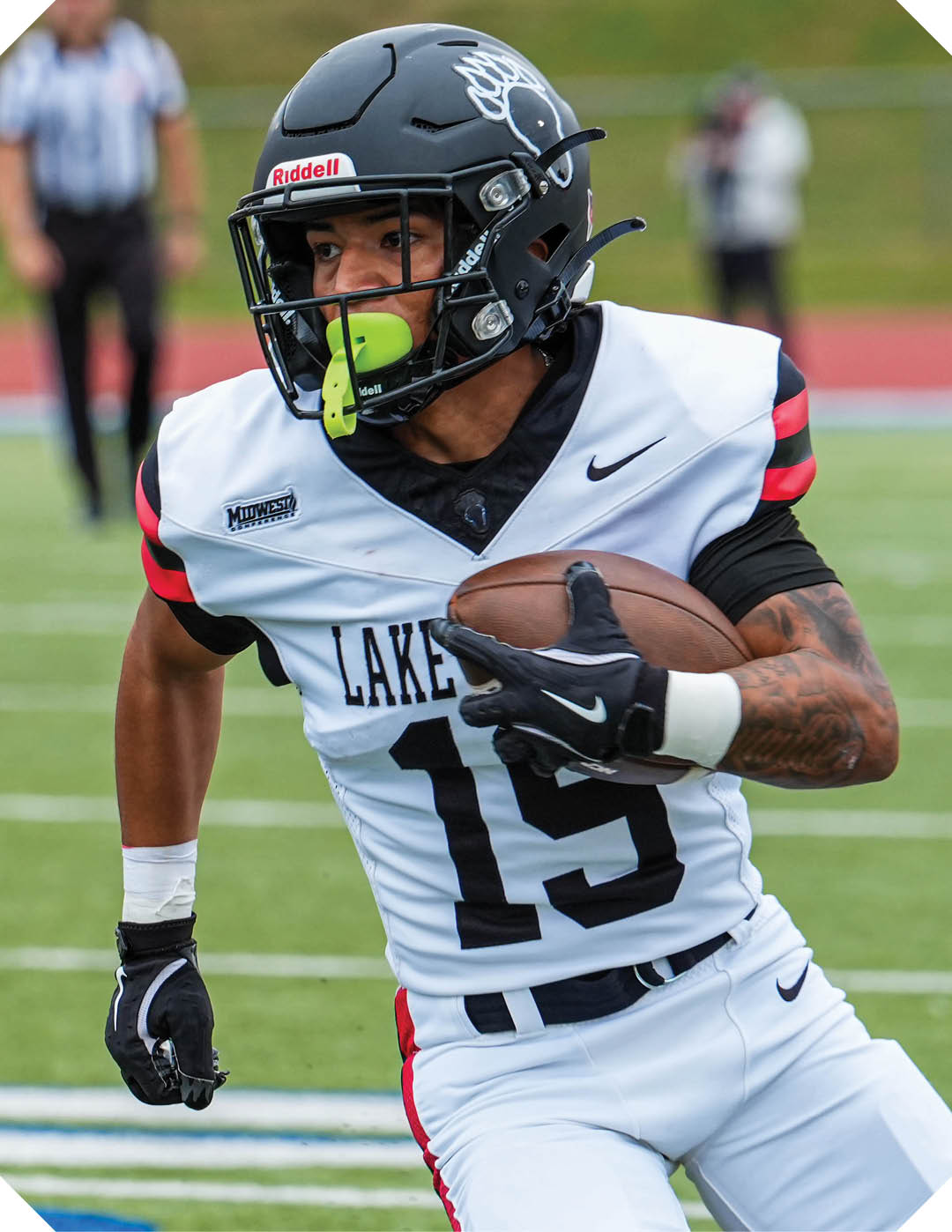 A young man wearing a black and white jersey with the word Vista on it stands on a field. AI generated content
