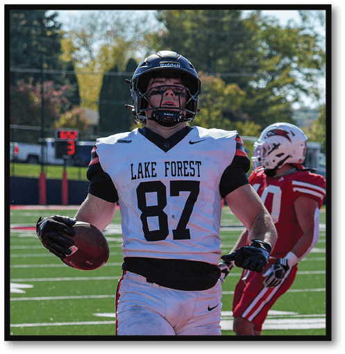 A football player wearing a black jersey with the number 6 on it. Description generated by AI