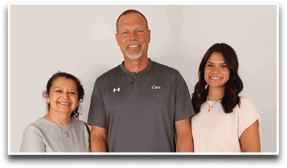Three adults wearing football jerseys with the number 3 pose smiling against a dark background, with one holding a football. Description generated by AI