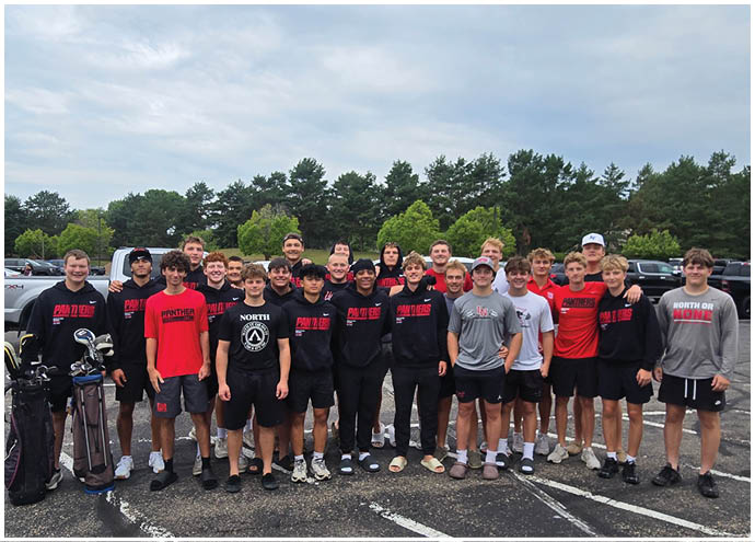 A group of people wearing casual sportswear and standing closely together outdoors in a parking lot with trees and cars in the background. Description generated by AI