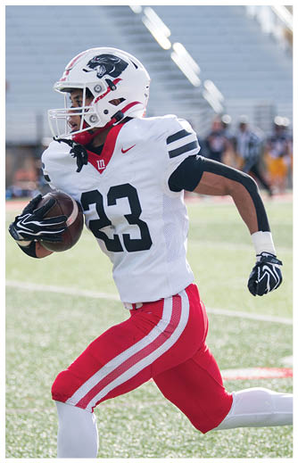 A person wearing a white football uniform with the number 23 is running on a field while holding a football. Description generated by AI