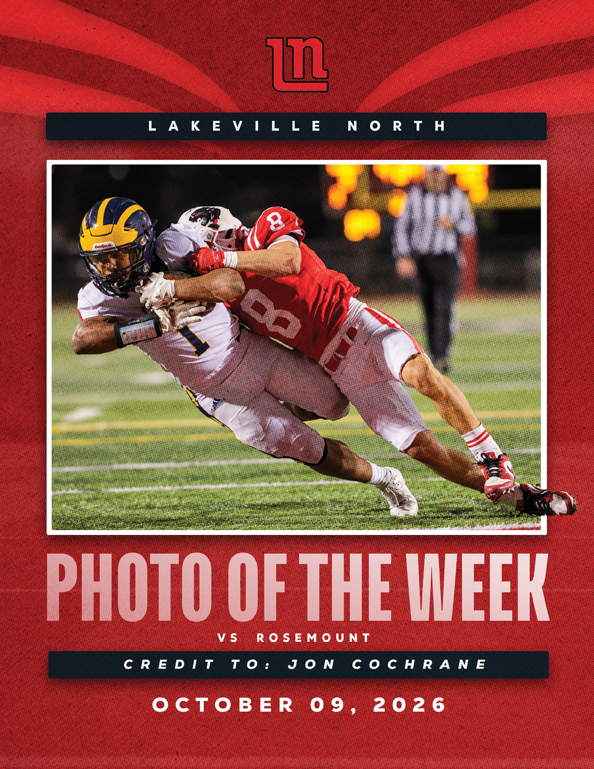 Two football players in action on a field with one player in a red uniform tackling another player in a white uniform with a yellow and blue helmet during a night game. Description generated by AI