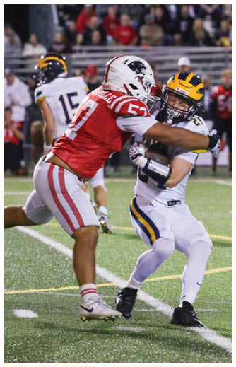 A person wearing a red sports jersey with the number 7 and white pants with red stripes is on a sports field with another person in a white jersey numbered 15 in the background. Description generated by AI