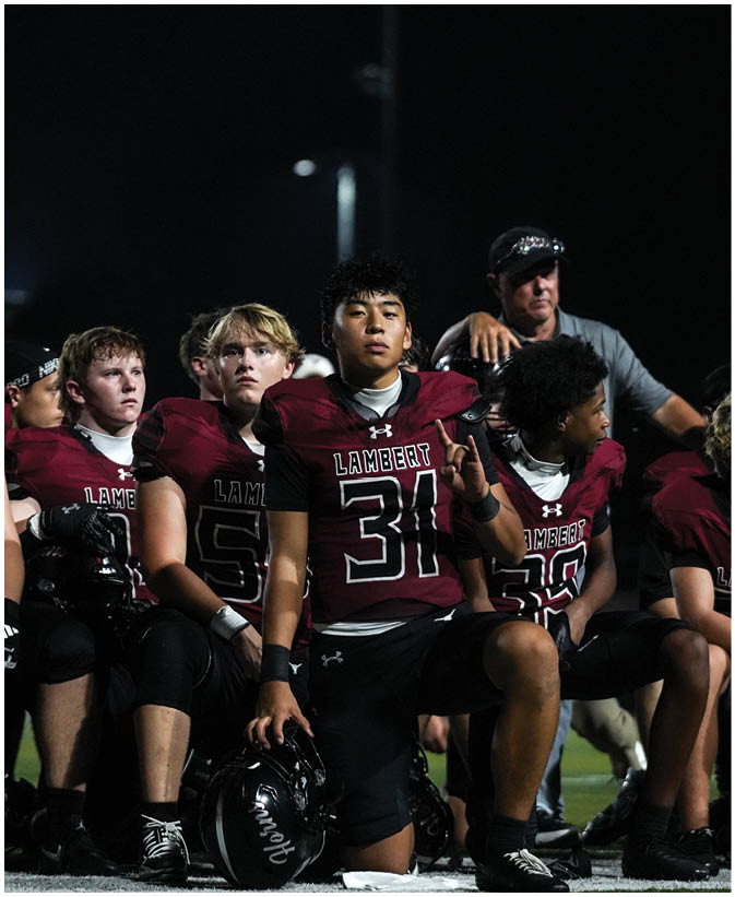 A group of football players on a field. Description generated by AI