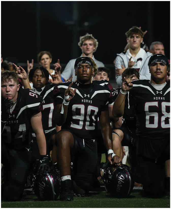 A group of football players on a field. Description generated by AI