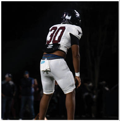 A football player running on the field. Description generated by AI