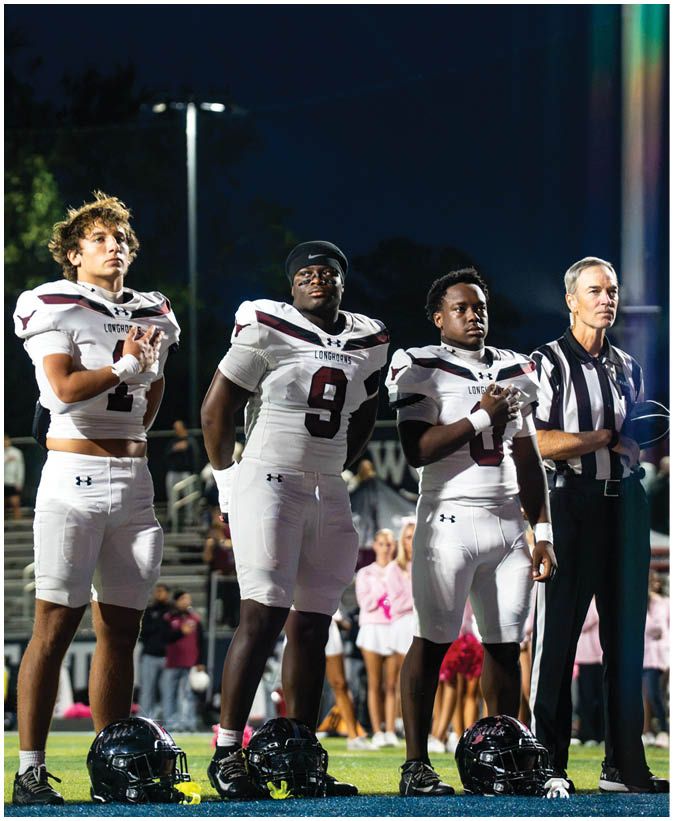 A group of football players on a field. Description generated by AI