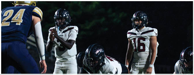 A group of football players on a field. Description generated by AI