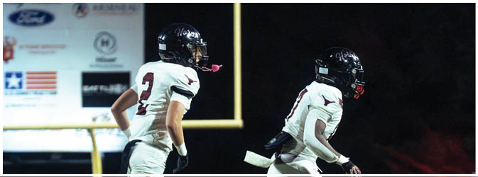 A football game is taking place on a field with players wearing blue and white uniforms. Description generated by AI