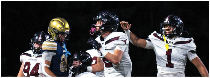 A football game is taking place on a field with players wearing blue and white uniforms. Description generated by AI