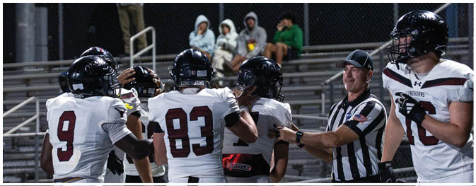A group of football players on a field. Description generated by AI