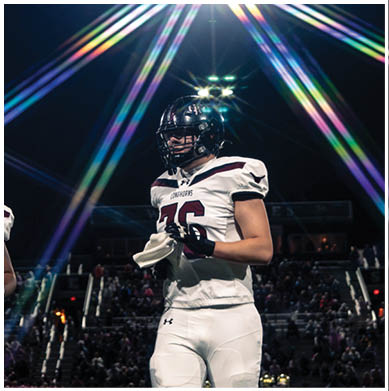 A football player running on the field. Description generated by AI
