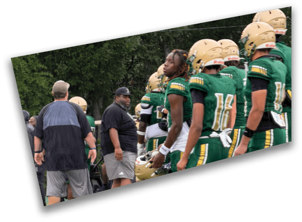 People wearing athletic shoes and sportswear are standing on a green turf field near a white line. Description generated by AI