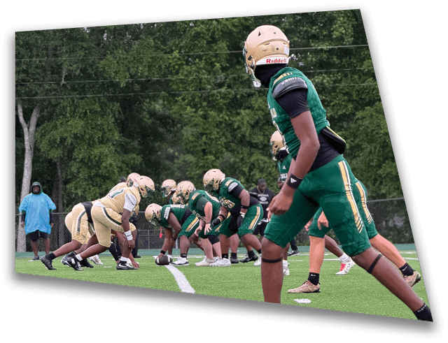 Two teams in football uniforms are lined up on a green field facing each other, preparing for a play. Description generated by AI