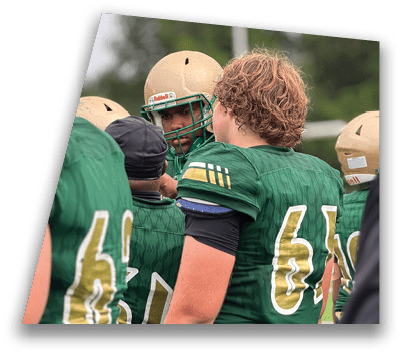 Two people in green football uniforms are closely interacting, with one wearing a gold helmet and the other showing curly hair. Description generated by AI