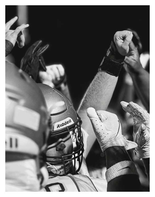 A football player wearing a helmet and white uniform is holding his helmet above his head. AI generated content