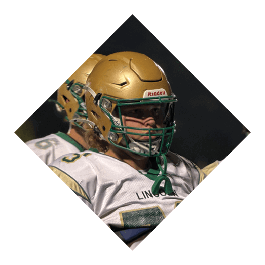 A football player wearing a black jersey with the number 10 sits on the ground with a football helmet on the ground next to him. AI generated content