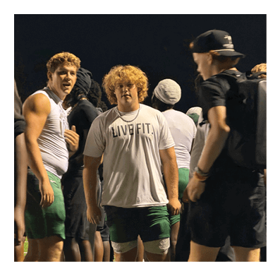 Two men wearing football helmets are talking to each other. AI generated content