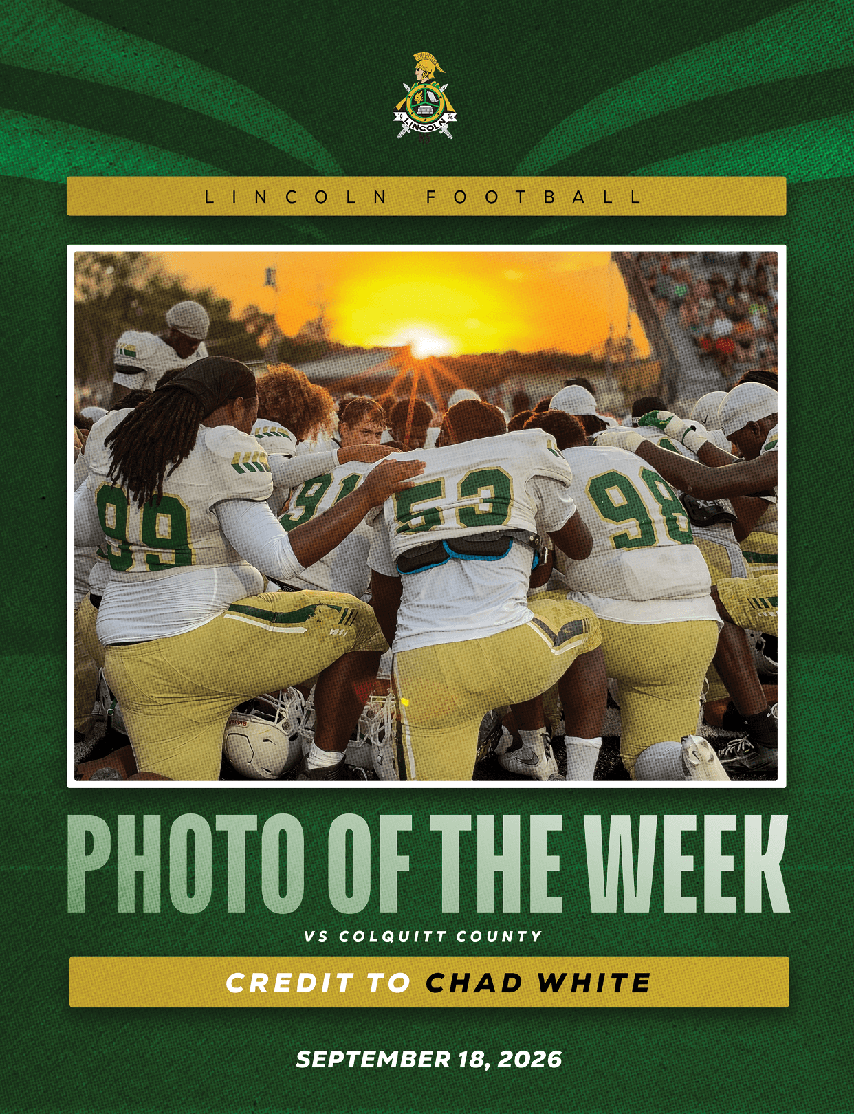 A group of football players in green and gold uniforms kneel together in a huddle at sunset on a field with spectators in the background. Description generated by AI