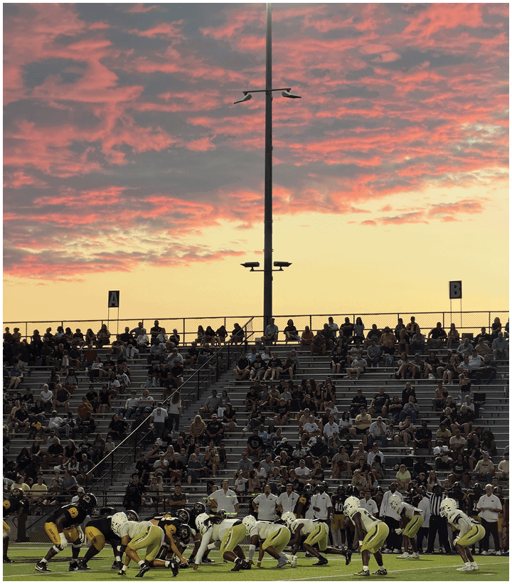A streetlight with two lamps is set against a sky filled with pink and gray clouds during sunset. Description generated by AI