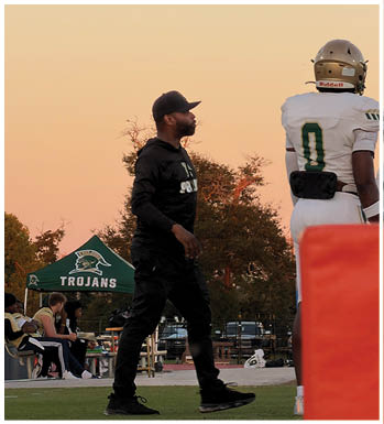 Two people wearing sports helmets and gear are standing outdoors against a clear sky during sunset. Description generated by AI