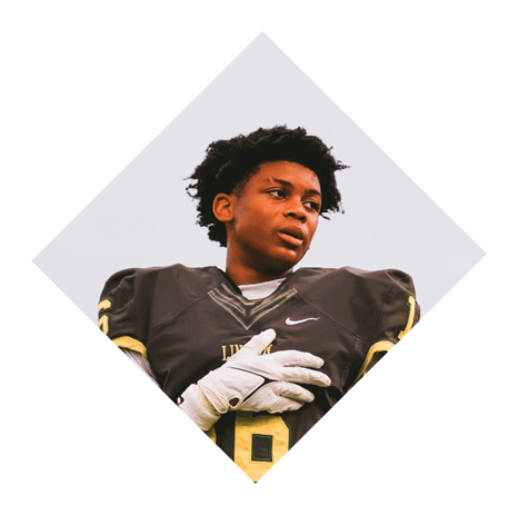 A football player wearing a black jersey with the number 3 kneels on the field. AI generated content
