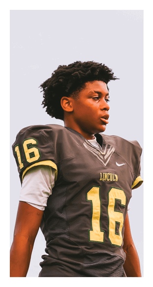 A person wearing a black football jersey with the number 16 and the word Lincoln stands looking to the side against a plain background. Description generated by AI