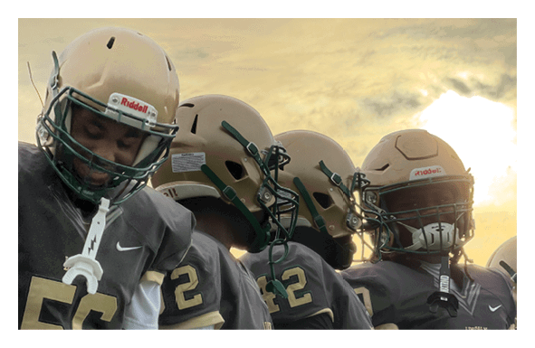 Three people wearing helmets are seen from behind against a cloudy sky background. Description generated by AI