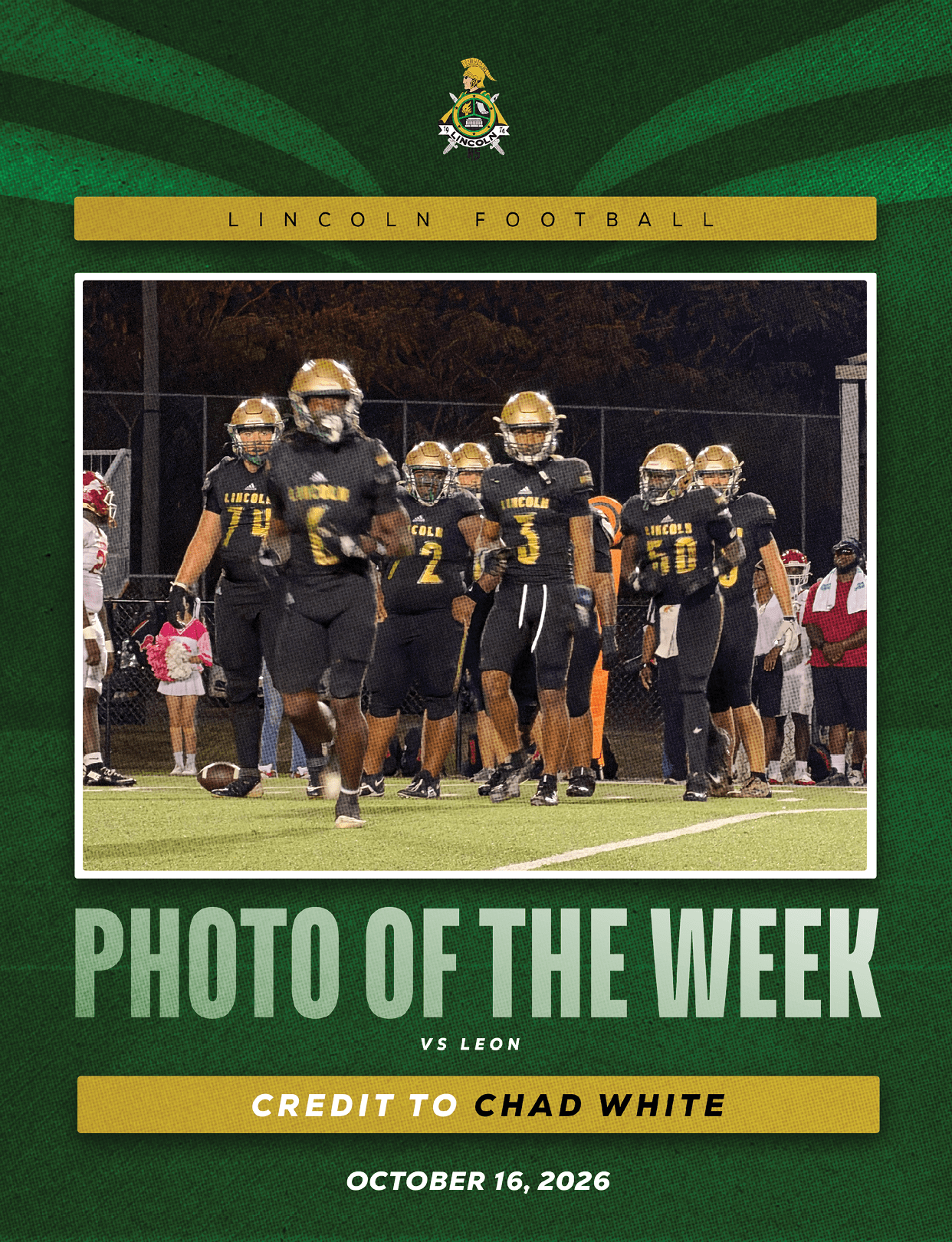A group of football players in black and gold uniforms are walking on a field during a nighttime game with spectators in the background. Description generated by AI