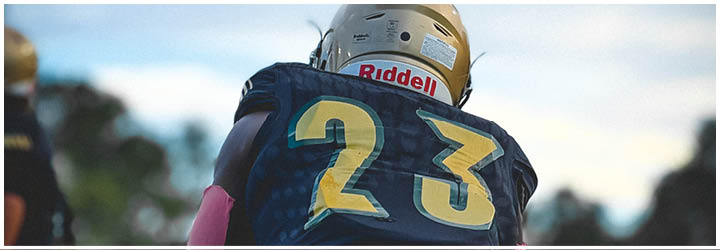 A person wearing a dark sports jersey with yellow and green stripes on the shoulders and a visible Puma logo on the collar. Description generated by AI