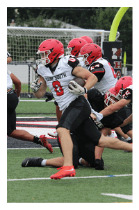 People wearing athletic clothing and cleats are engaged in a sports activity on a turf field. Description generated by AI