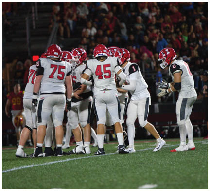 A group of football players on a field. Description generated by AI