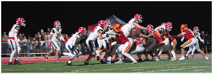A group of football players on a field. Description generated by AI