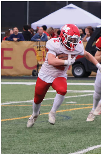 A person wearing a red and yellow football uniform with the number 9 is running on a football field while other players and spectators are visible in the background. Description generated by AI
