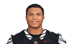 A person wearing a black football uniform with the word “HAWKS" and the number 3 stands with hands behind their back against a transparent background. Description generated by AI