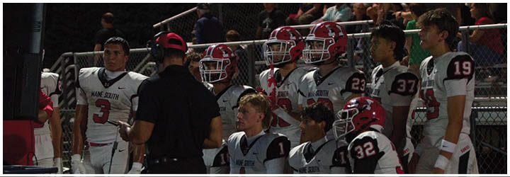 A group of football players on a field. Description generated by AI