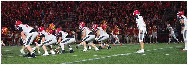 A group of football players on a field. Description generated by AI