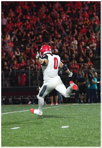 A football player running on the field. Description generated by AI