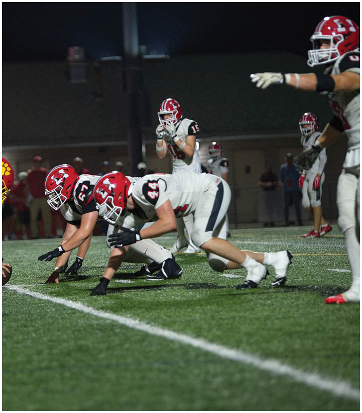 A group of football players wearing black and white uniforms. Description generated by AI