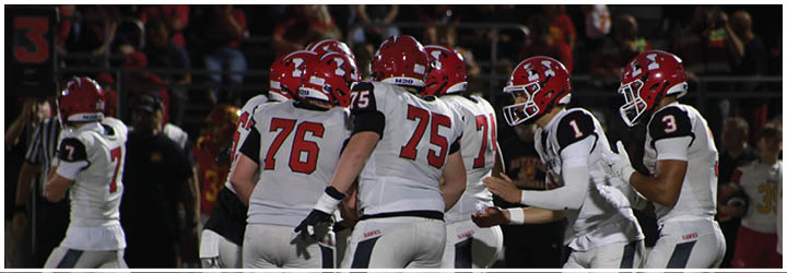 A group of football players on a field. Description generated by AI