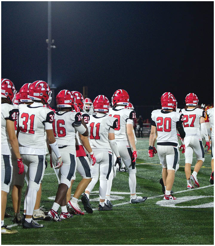 A group of football players wearing black and white uniforms. Description generated by AI