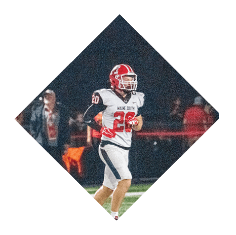 A person wearing a red helmet, white jersey with the number seven, and black pants is standing on a football field. Description generated by AI