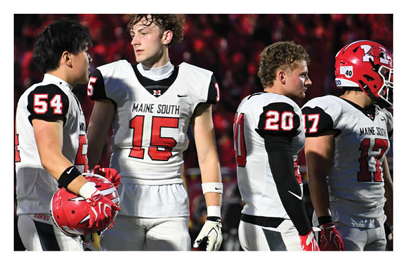 People wearing sports gear are engaged in a football game on a field with marked lines and a large red and white logo. Description generated by AI
