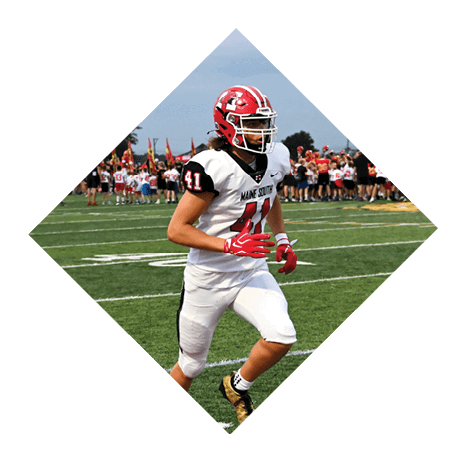 A person wearing a red helmet and white football uniform with the number 41 is running on a football field with a crowd in the background. Description generated by AI