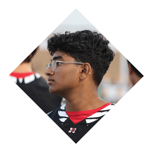 A person with curly hair and glasses is shown in profile wearing a red shirt. Description generated by AI
