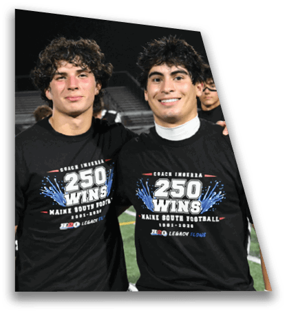 Two people wearing black shirts celebrating a football coach's 250 wins at a nighttime outdoor event. Description generated by AI
