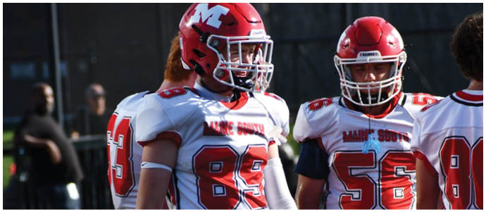People wearing white and red football uniforms with visible numbers 89, 56, and 80 standing close together. Description generated by AI