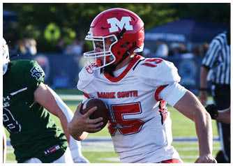 Two people in football uniforms are engaged in a play on a field, with one holding the ball and the other attempting to catch or tackle. Description generated by AI