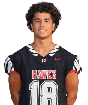 A person with curly hair is smiling and wearing a black sports jersey with the word “HAWKS" and the number 18 on it. Description generated by AI