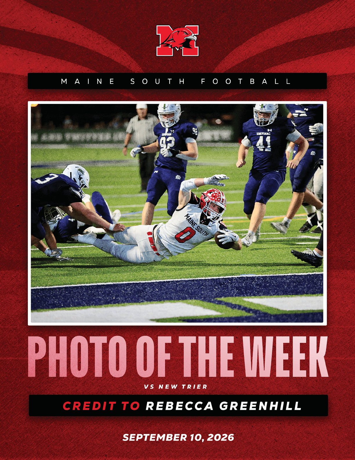 A football player in a white uniform dives forward with the ball while several players in dark uniforms approach on a green field during a game between Maine South and New Trier. Description generated by AI